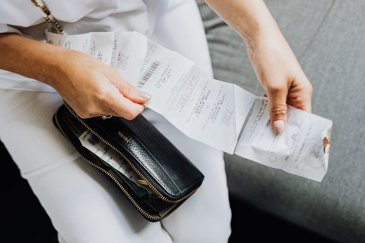 Revisando tickets de compra junto a una cartera para controlar los gastos del mes
